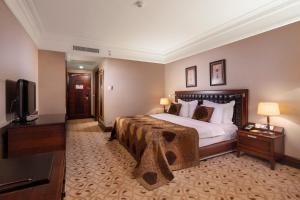 イスタンブールにあるクラウン プラザ イスタンブール アジアのベッド1台、薄型テレビが備わるホテルルームです。