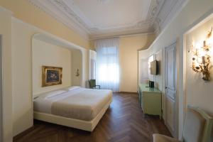 a bedroom with a bed and a room with a mirror at Grand Hotel Liberty in Riva del Garda