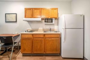 a kitchen with a white refrigerator and a sink at WoodSpring Suites Corpus Christi in Corpus Christi