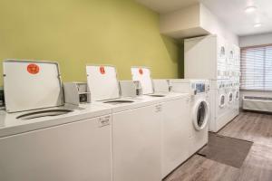 eine Waschküche mit weißen Maschinen und grünen Wänden in der Unterkunft WoodSpring Suites Corpus Christi in Corpus Christi