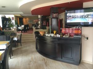 a bar in a restaurant with a tv on the wall at Hotel Adria in Prishtinë
