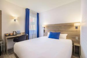 Hotel Le Circuit Le Mans tesisinde bir odada yatak veya yataklar