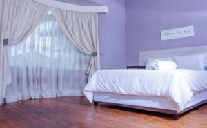 1 dormitorio con cama blanca y ventana en KK GUEST HOUSE en Brakpan