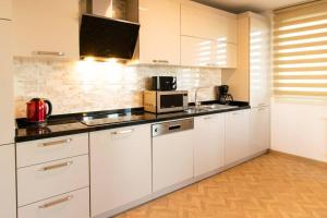 cocina con armarios blancos y microondas en Royal Residence Maiden Tower en Estambul