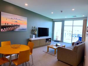 uma sala de estar com uma mesa e uma televisão em Wallaroo Marina Luxury Apartment em Wallaroo