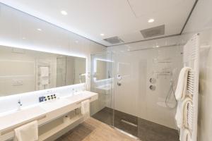 a bathroom with a shower and a sink and a mirror at Grand Hotel Liberty in Riva del Garda