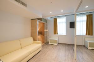a living room with a couch and a television at Grand Hotel Liberty in Riva del Garda