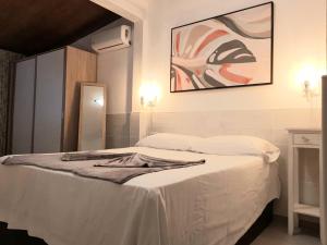 タラハレホにあるTarajalejo Eco Ocean Bの白いベッド1台付きのベッドルーム1室(壁に絵画付)
