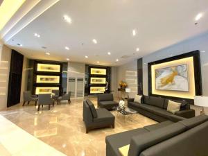 a large living room with couches and chairs at Fame Residences T1 Family Suite 1507 in Manila
