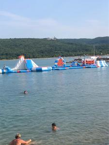 a group of people swimming in the water with slides at Apartman Igor in Čižići