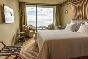a hotel room with a bed and a large window at Vila Foz Hotel & SPA - member of Design Hotels in Porto