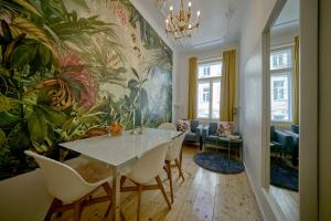 ein Esszimmer mit einem Tisch, Stühlen und einem Wandbild in der Unterkunft Leuhusen Collection Vienna in Wien