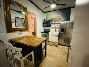 a kitchen with a table and a refrigerator at Emmanuelli Sur 3 Bedroom Home in San Juan