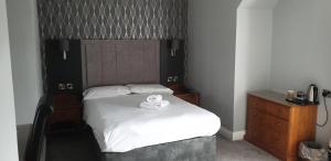 a bedroom with a bed with a teddy bear on it at The Diplomat Hotel Restaurant & Spa in Llanelli