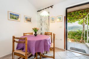 comedor con mesa, sillas y ventana en Apartments Mandica en Rabac