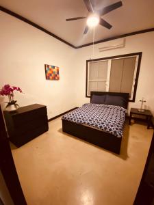 een slaapkamer met een bed en een plafondventilator bij Emmanuelli Sur 3 Bedroom Home in San Juan