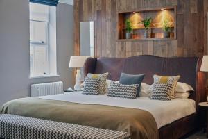 a bedroom with a large bed with pillows on it at Hotel du Vin Birmingham in Birmingham