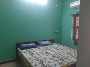 a bed in a blue room with two pillows on it at Padmavathi Home Stay in Chidambaram