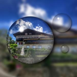 a reflection of a building in a side view mirror at Gasthof Stiegenwirt in Parcines