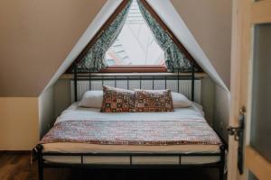 Bett in einem Zimmer mit einem Fenster und einem Bett sidx sidx sidx sidx in der Unterkunft Apartament Górski u Papierzy in Witów