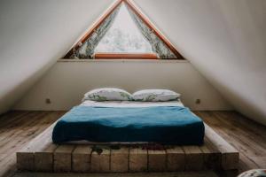 Bett in einem Zimmer mit einem großen Fenster in der Unterkunft Apartament Górski u Papierzy in Witów