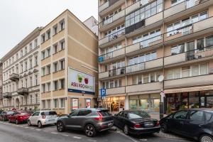ulica z samochodami zaparkowanymi przed wysokimi budynkami w obiekcie Wilcza 26A by Homeprime w Warszawie