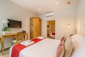 a bedroom with a bed and a desk and a television at Viewpoint Boutique Living in Xlendi