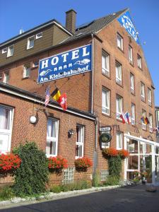 Hotel Am Kleinbahnhof في إمدن: فندق فيه لافته على مبنى من الطوب