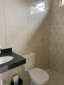a bathroom with a white toilet and a sink at Hostel Pigally in Goiânia