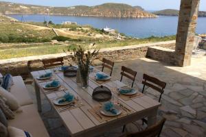 una mesa con sillas y vistas al agua en Chez Semiramis The Summer Breeze House for 13 persons 5'min from the beach, en Serifos Chora