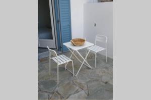 una mesa blanca y sillas en un patio en Chez Semiramis The Summer Breeze House for 13 persons 5'min from the beach, en Serifos Chora