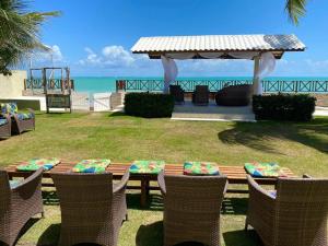 Ipioca Beach Village في ماسيو: طاولة نزهة مع كراسي وشرفة على الشاطئ