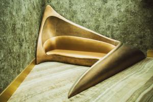 a gold chair sitting on top of a bed at Vila Foz Hotel & SPA - member of Design Hotels in Porto