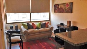 salon z kanapą i stołem w obiekcie Apartamentos Costanera Centre w mieście Santiago