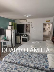 a bedroom with a large bed and a kitchen at Pousada Temporada Maceió in Maceió