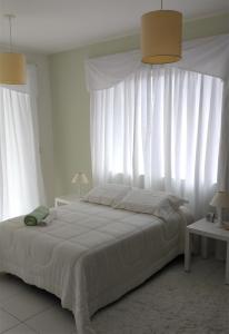 a bedroom with a large bed with white curtains at Casa Portogalo + Lancha (Opcional) in Angra dos Reis +37 photos