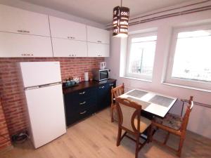 a kitchen with a white refrigerator and a table at Apartment ELLA in Tuzla
