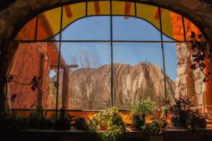 una finestra con piante in vaso e vista sulle montagne di El Rastrojo - Casa de campo a Tilcara Altre 5 foto