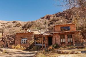 una vieja casa de ladrillo frente a una montaña en El Rastrojo - Casa de campo en Tilcara