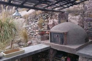 un forno all'aperto con lavandino e muro di pietra di El Rastrojo - Casa de campo a Tilcara
