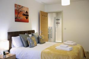 a bedroom with a bed with two towels on it at FW Haute Apartments at Queensbury, Ground Floor 2 Bedrooms and 2 Bathrooms with King or Twin beds with Front Porch and FREE WIFI and PARKING in Wealdstone