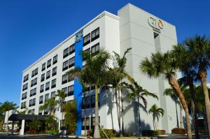 a white building with palm trees in front of it at Best Western Plus Ft Lauderdale Hollywood Airport Hotel in Hollywood