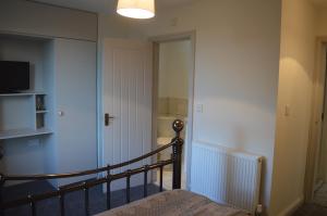 a room with a staircase and a door with a television at Foxhill Bank in Oswaldtwistle