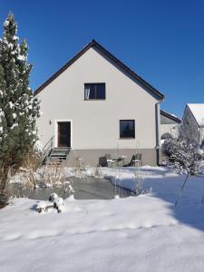 a large white house with snow on the ground at FeWo Rohleder de mit 130m2 und Garten für 6Pers mit 2 Bad in Cottbus