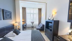 een hotelkamer met een bed en een televisie bij Hotel Chariot in Aalsmeer