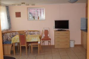 ein Wohnzimmer mit einem Tisch und einem TV in der Unterkunft Apartment Robert in Maiersdorf