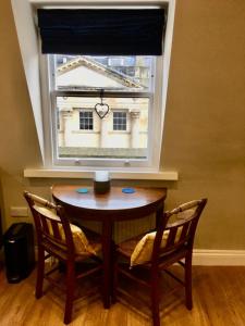 a table and two chairs in front of a window at Beautiful Bath Apartment in iconic Milsom Street Location in Bath