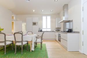 a kitchen with a table and chairs and a kitchen with white cabinets at MIT House San Anton II en Madrid in Madrid
