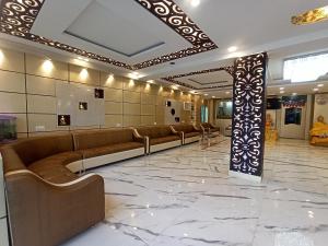 a waiting room with couches and a column in a building at Hotel Om International in Bodh Gaya
