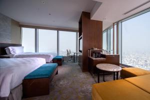 a hotel room with two beds and a large window at Osaka Marriott Miyako Hotel in Osaka